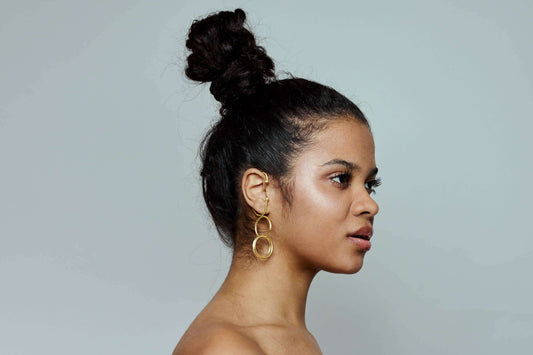 Model met grote gouden oorbellen, boho stijl, natuurlijke materialen
