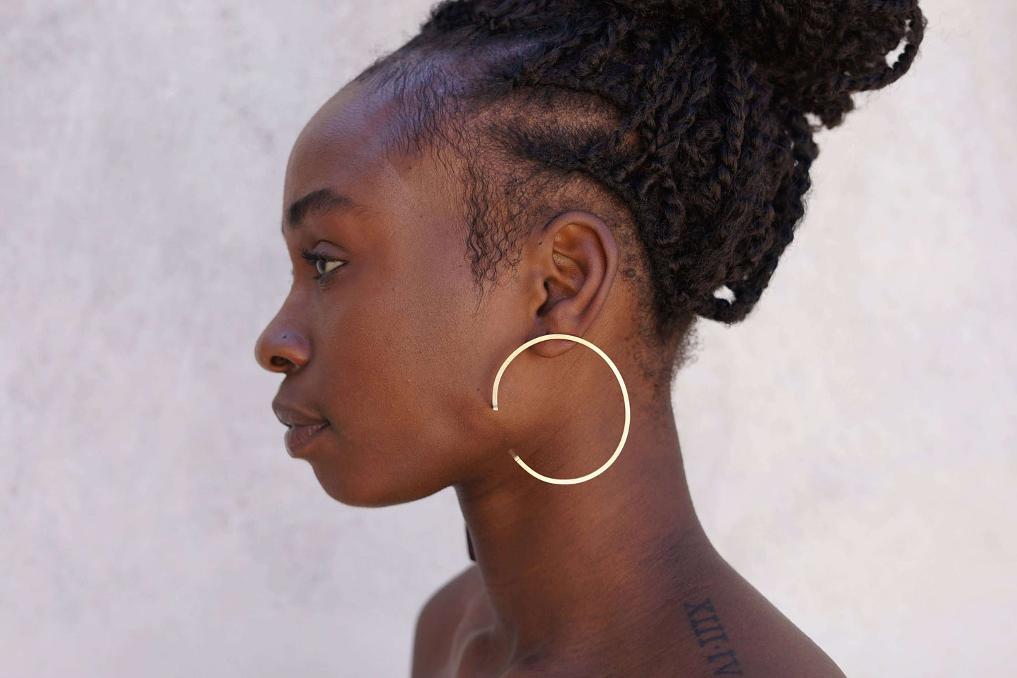Moedel met unieke messing oorbellen met asymmetrisch design voor een creatieve stijl