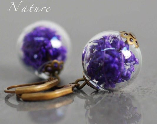 Unieke droogbloemen oorbellen met glazen bol en gouden details