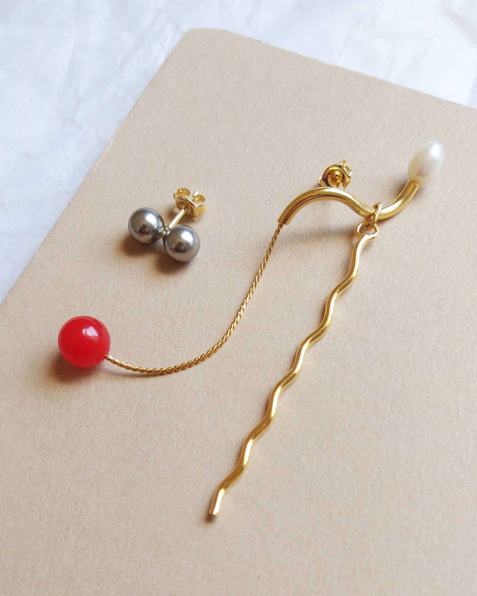Stijlvolle oorbellen met parel en gouden kettingdetail
