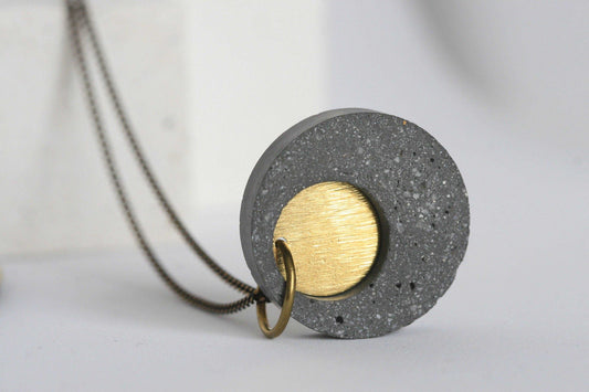 Detail van beton ketting met gouden element en ketting