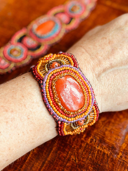 Kleurrijke kralenarmband met grote oranje steen en gedetailleerd ontwerp