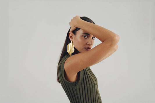 Model met grote messing oorbellen en groene top