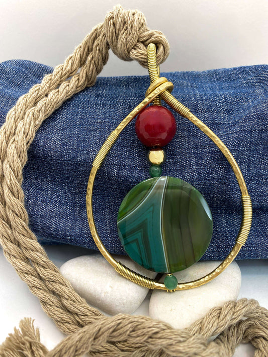 Close-up van de RAAK.Halsketting ERISA met grote groene steen en gouden metalen frame