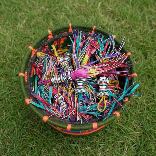 gecombineerde kleurrijke sleutelhangers in een mand op gras