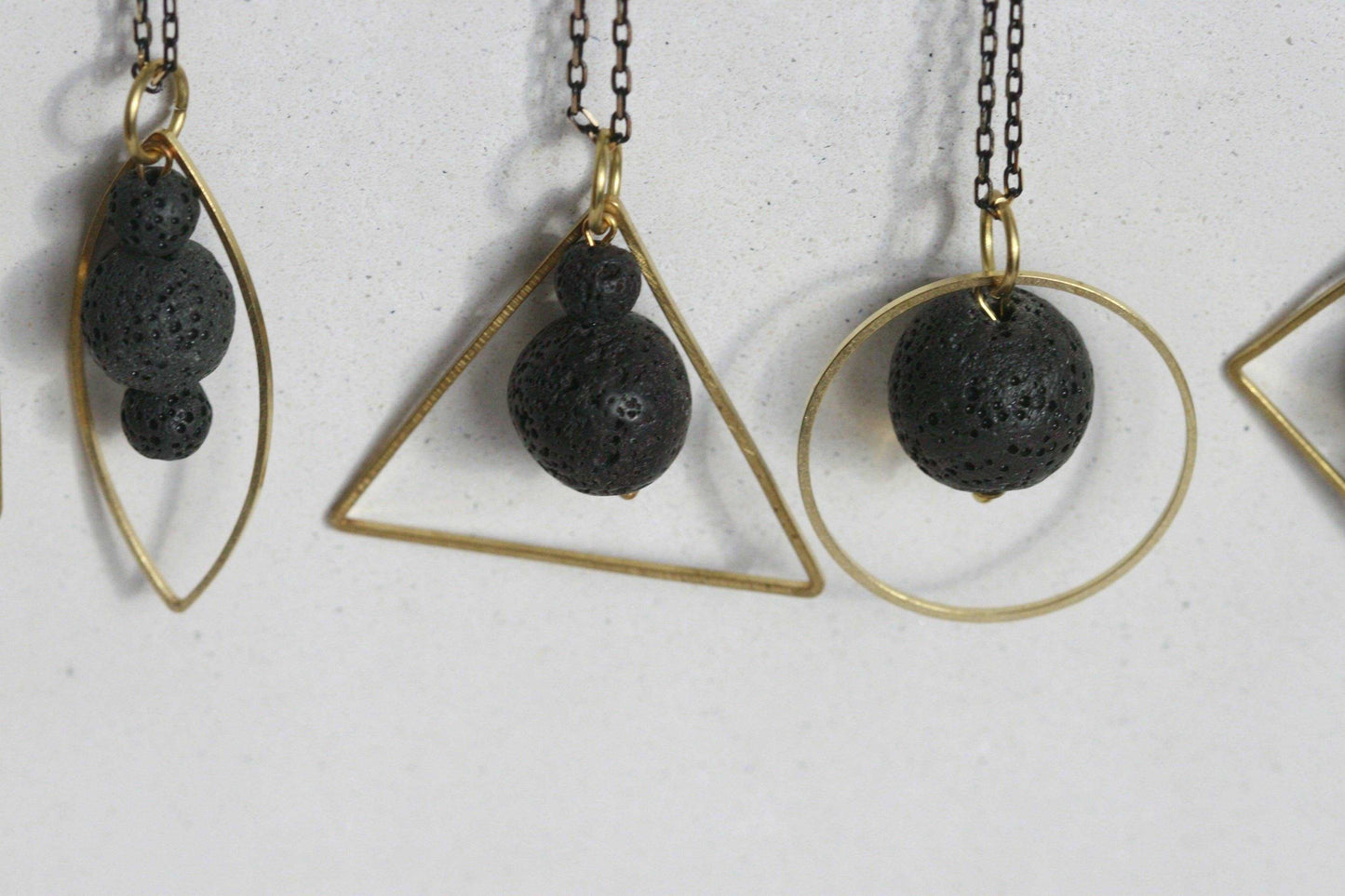 Overzicht LAVA.ELEMENTEN diffuser ketting met lavasteen en gouden geometrisch frame