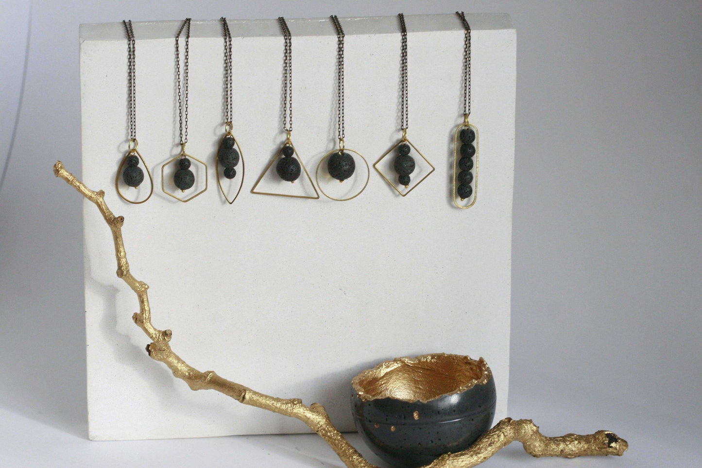 Zwart lavasteen diffuser ketting met gouden metalen omtrek, handgemaakt in Ierland