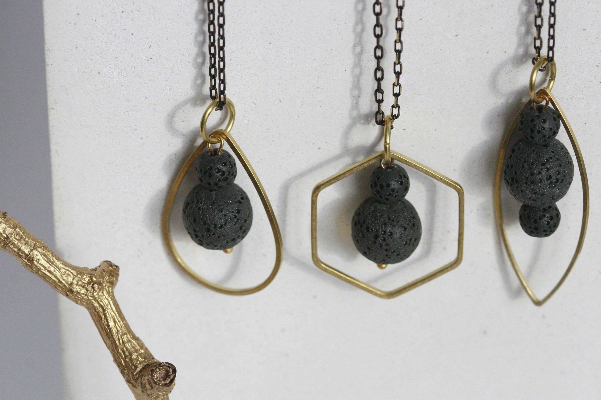 Close-up van zwart lavasteen diffuser ketting met gouden metalen frame, handgemaakt in Ierland