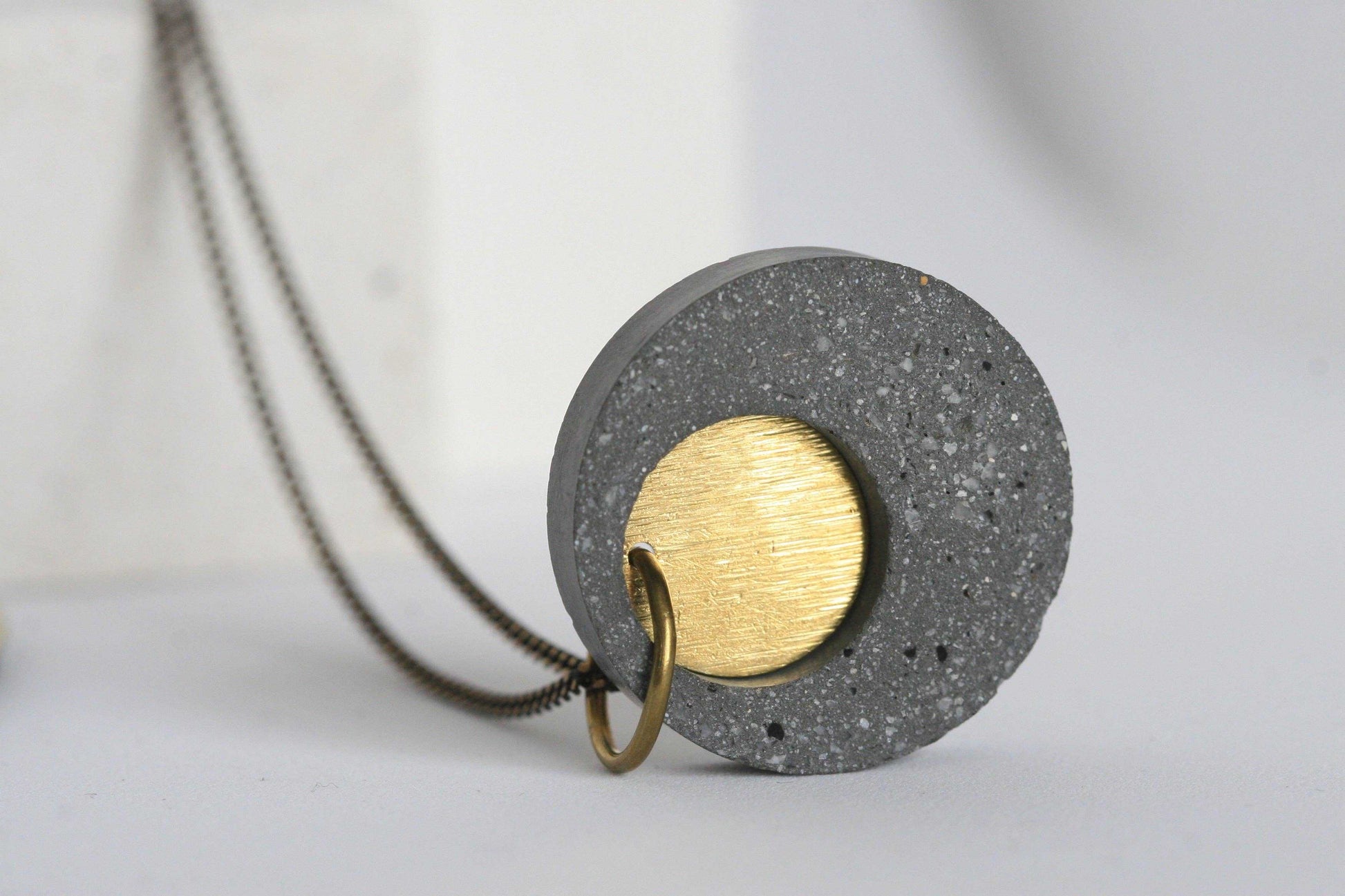 Detail van beton ketting met gouden element en ketting
