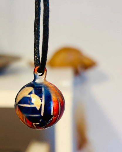 Hanger geëmailleerd met belletje aan zwart koord, handgemaakt sieraad