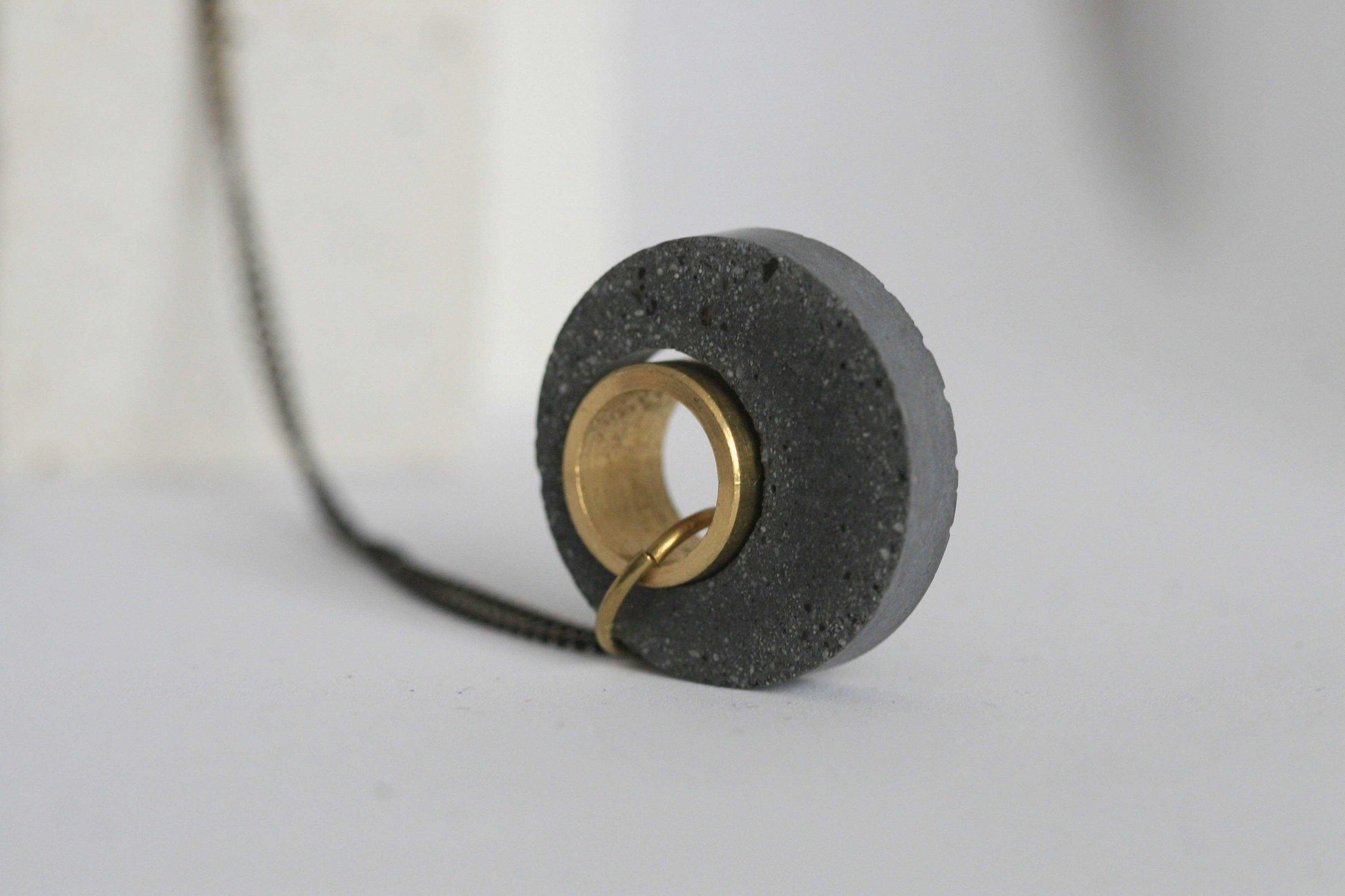 Beton ketting met gouden ring en zwart koord