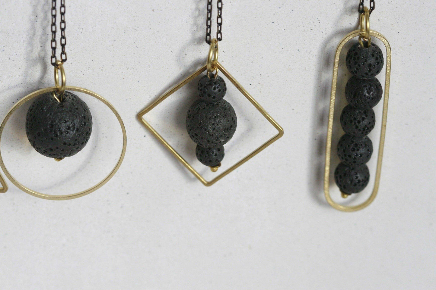 LAVA.ELEMENTEN diffuser ketting met lavasteen en gouden geometrisch frame