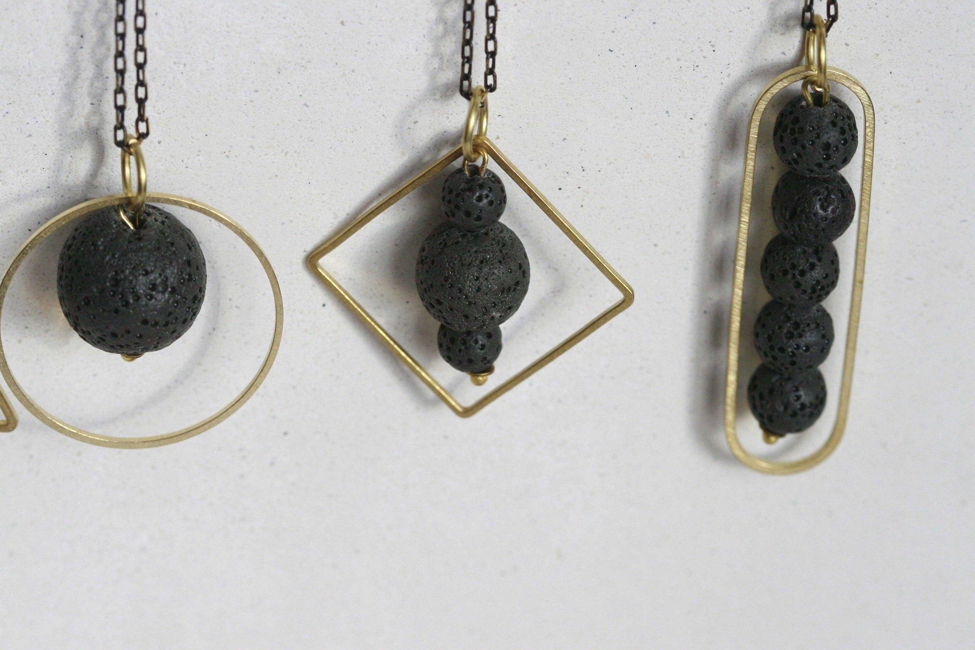 LAVA.ELEMENTEN diffuser ketting met lavasteen en gouden geometrisch frame